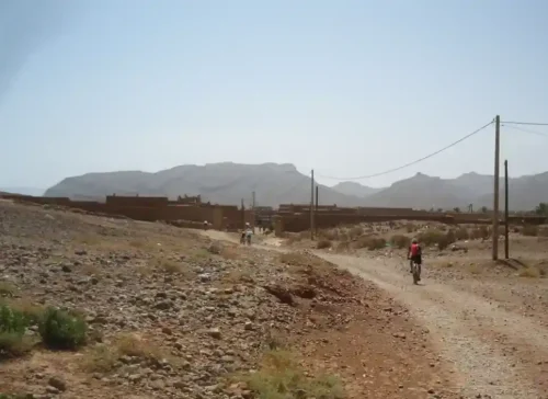Ciclistas recorriendo una pista pedregosa en el valle del Draa, Marruecos.